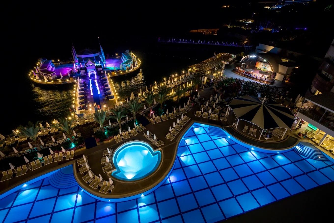 Orange County Hotels'te gece ışıklandırılmış havuzlar, iskele ve sahnenin yukarıdan görünümü